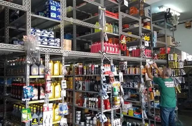 Atendente organizando peças nas prateleiras da Tureta Auto Peças